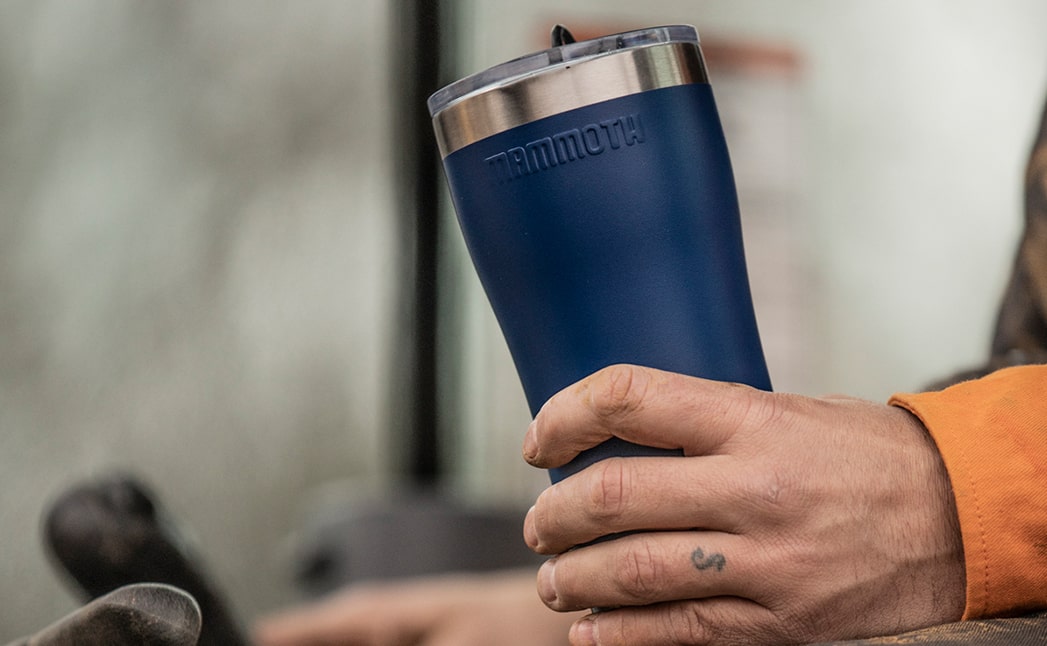 person holding blue 20 ounce rover tumbler